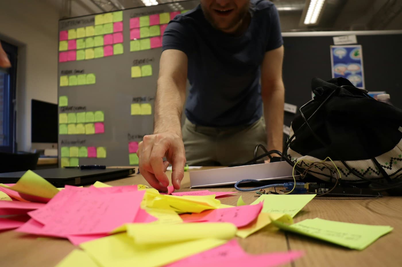 Een workshopdeelnemer sorteert gekleurde notities voor een planbord